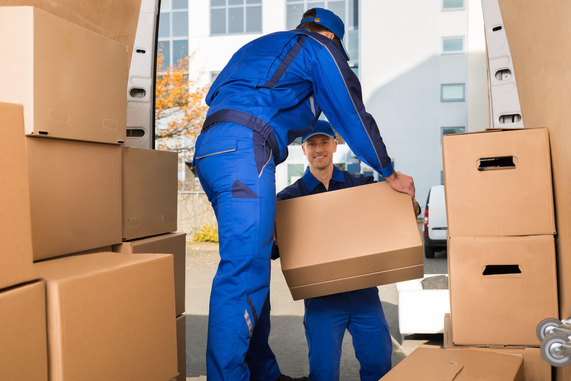 Movers Carrying Sofa Outside Truck On Street