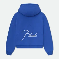 In the fast-evolving world of fashion, few brands have managed to bridge the gap between luxury and streetwear as seamlessly as Rhude Clothing. Founded in Los Angeles, Rhude is not just a brand—it's a statement. It captures the grit of the streets and infuses it with high-end craftsmanship, resonating with a generation that values authenticity, edge, and exclusivity. The Origin of Rhude Clothing Rhude was founded in 2015 by designer Rhuigi Villaseñor, a self-taught creative who immigrated to the United States from the Philippines at age 11. With no formal fashion school training, Villaseñor learned by watching his mother, a tailor, and by immersing himself in the culture of Los Angeles. He quickly gained a cult following after his first T-shirt—a now-iconic design featuring a bandana print and the word “Rhude”—was spotted on celebrities like Kendrick Lamar. What started as a humble T-shirt collection evolved into a globally recognized fashion brand. Today, Rhude Clothing is a staple in the wardrobes of hip-hop artists, NBA stars, and fashion-forward elites. The Philosophy Behind Rhude Clothing At its core, Rhude Clothing embodies contrasts: youth vs. maturity, street vs. high fashion, American identity vs. global heritage. Villaseñor describes his brand as a “visual commentary on the American experience,” using clothing as a form of storytelling. Rhude pieces often reflect themes of nostalgia—vintage racing logos, Americana aesthetics, or silhouettes borrowed from 90s sportswear—but are executed with an elevated, refined twist. Each piece reflects a convergence of culture, comfort, and couture. Signature Styles and Collections Rhude is known for its mix of relaxed silhouettes, luxurious fabrics, and provocative graphics. Some of the standout elements that define Rhude Clothing include: Graphic Tees: From minimalist logos to statement prints, Rhude’s T-shirts are bold, clean, and effortlessly cool. Cigarette Track Pants: A signature style of the brand, these pants combine streetwear flair with tailored details like side stripes and cropped hems. Outerwear: Rhude jackets—often varsity, bomber, or denim—feature vintage racing insignias, nostalgic patches, and premium fabrics. Footwear: Collaborations with brands like Puma and Vans brought Rhude’s aesthetic to a wider audience, with sneakers that combine function, flair, and fashion. Accessories: From trucker hats to luxury sunglasses, accessories in the Rhude universe carry the same gritty-glam ethos. Collaborations That Cemented Its Influence Rhude Clothing's rise has been marked by strategic collaborations with major players in both fashion and sports industries. Some notable partnerships include: Rhude x Puma: One of the brand’s most successful collaborations, this collection merged Rhude’s LA street style with Puma’s athletic legacy. It resulted in sleek, retro sneakers and apparel that sold out quickly. Rhude x Thierry Lasry: For those looking to elevate their eyewear game, this collaboration offered sunglasses with bold frames and a touch of rebellion. Rhude x McLaren: Racing culture has always inspired Rhuigi, and this collaboration celebrated that intersection—fusing speed, style, and luxury in one capsule collection. These collaborations not only widened Rhude’s audience but solidified its position at the intersection of fashion, sport, and pop culture. Celebrity Endorsement and Cultural Impact One cannot discuss Rhude Clothing without acknowledging its strong connection to celebrity culture. Its early adoption by tastemakers gave it a level of credibility that most emerging brands can only dream of. Artists and athletes like LeBron James, A$AP Rocky, Future, Justin Bieber, Jay-Z, and The Weeknd have all been spotted in Rhude. Even high-fashion icons like GQ and Vogue have given the brand praise, noting its ability to inject real cultural substance into luxury streetwear. This visibility has helped Rhude become not just a brand—but a lifestyle. It speaks to those who are ambitious, edgy, and unapologetically bold. Quality and Production While many streetwear labels rely heavily on graphic appeal, Rhude Clothing distinguishes itself through quality craftsmanship. Most pieces are made in the U.S. or Italy, ensuring meticulous construction and premium fabric selection. Villaseñor has expressed that he wants Rhude to stand shoulder-to-shoulder with traditional luxury houses—not just in aesthetics but in make and feel. That emphasis on quality is part of what justifies the price point of Rhude garments, many of which retail from $200 to over $1,000. But for fans of the brand, it’s more than worth it. Rhude on the Runway Rhude is no longer confined to just the streets—it’s thriving on the runway. Debuting at Paris Fashion Week in 2020, the brand impressed critics and fans alike with its sleek yet disruptive collection. It was a clear message: Rhude had transcended the streetwear niche and entered the global high-fashion stage. Villaseñor’s presentations blend traditional showmanship with personal storytelling. His collections often draw on his immigrant roots, the immigrant hustle, American symbols, and the tension between luxury aspiration and street-born reality. The Future of Rhude Clothing With Rhuigi Villaseñor at the helm, the future of Rhude Clothing looks bright and expansive. In recent years, he has taken on new projects, including being the creative director of Bally (a Swiss luxury brand), showing his versatility as a designer. This cross-pollination between brands enriches Rhude’s DNA and opens new doors for creative experimentation. Villaseñor has also hinted at expanding Rhude into a full lifestyle brand—including potential ventures into fragrance, home goods, and even hospitality. As Gen Z and millennials continue to value brands that are not only stylish but purpose-driven, Rhude’s combination of storytelling, quality, and culture positions it perfectly for long-term relevance. How to Style Rhude Clothing Rhude’s unique blend of street and luxury means it can be styled in numerous ways: Street Chic: Pair Rhude’s signature track pants with a graphic tee and sneakers for a relaxed, off-duty look. Elevated Edge: Throw on a Rhude bomber jacket over a fitted turtleneck with loafers for a fashion-forward night out. High-Low Mix: Combine Rhude tees with tailored trousers or mix a Rhude hoodie with designer boots for a look that screams “casual wealth.” The versatility of Rhude’s pieces allows wearers to express a wide range of styles without losing that essential cool factor. Where to Buy Rhude Clothing Rhude is available through its official website as well as high-end retailers like SSENSE, Farfetch, Saks Fifth Avenue, MR PORTER, and Dover Street Market. Due to its limited drops and high demand, many items sell out quickly—making them even more desirable in the eyes of streetwear collectors and fashion enthusiasts. Final Thoughts Rhude Clothing represents more than just an aesthetic—it’s a movement rooted in heritage, ambition, and innovation. By effortlessly blending luxury with street sensibility, Rhude has carved out a unique lane that continues to influence the broader landscape of contemporary menswear. With Rhuigi Villaseñor’s visionary leadership and a loyal fanbase, Rhude isn’t just riding a trend—it’s setting the tone for what modern luxury streetwear can be.
